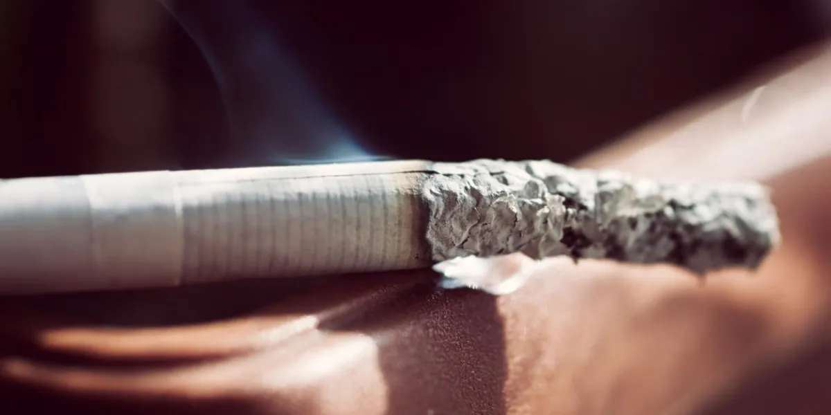 une cigarette fumante fumante blanche avec un filtre