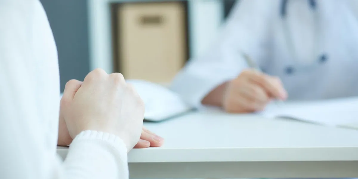 close up of patient's hands and doctor taking notes