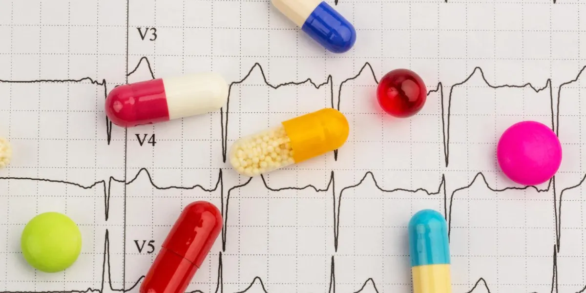 several pills are on an ekg symbolic photo for diseases of heart and circulation