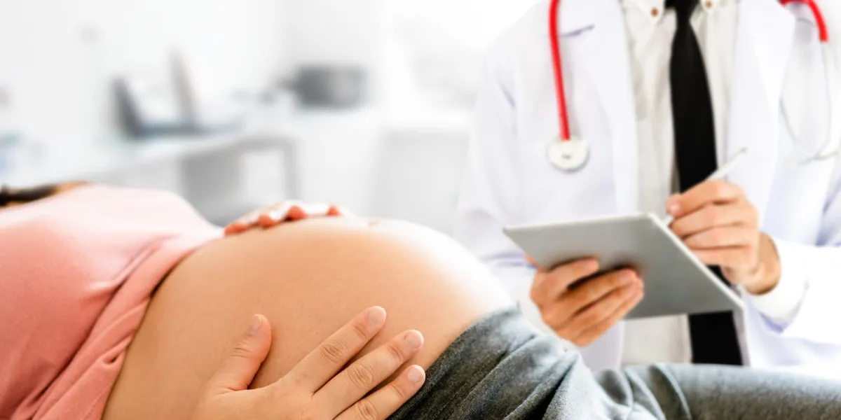happy pregnant woman visit gynecologist doctor at hospital or medical clinic for pregnancy consultant doctor examine pregnant belly for baby and mother healthcare check up gynecology concept