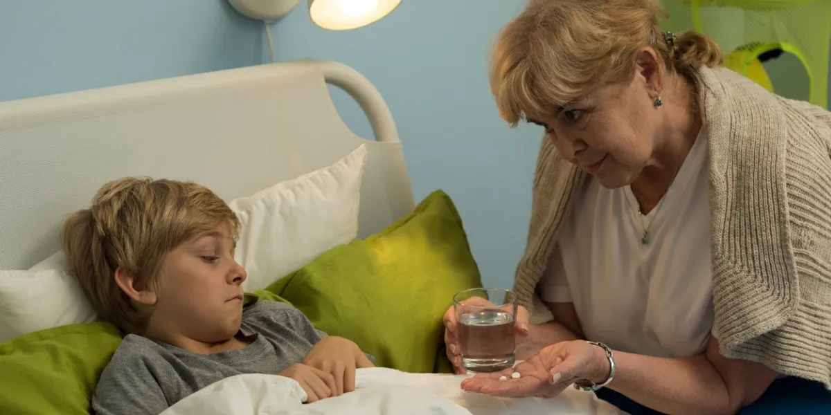 grandma caring about his ill grandchild lying in bed