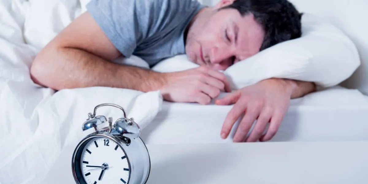 jeune homme séduisant, dormir sur le lit tôt le matin