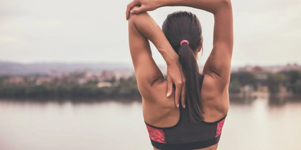 woman stretching and exercising outdoorimage is intentionally toned
