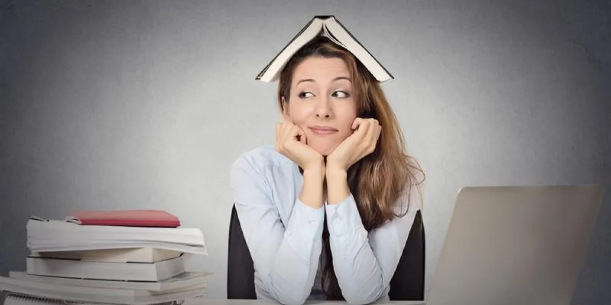 portrait agrandi, ennuyé, fatigué, femme, étudiant drôle avec livre sur la tête, assis au bureau, marre d'étudier, isolé gris tableau noir fond expression du visage, émotion, réaction
