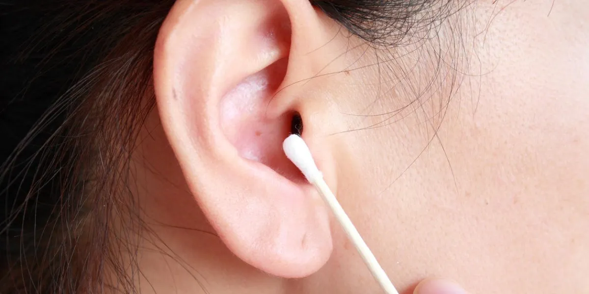 femme tenant un coton-tige et nettoyage de l'oreille