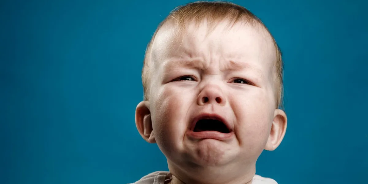 photo of nine month baby crying, isolated