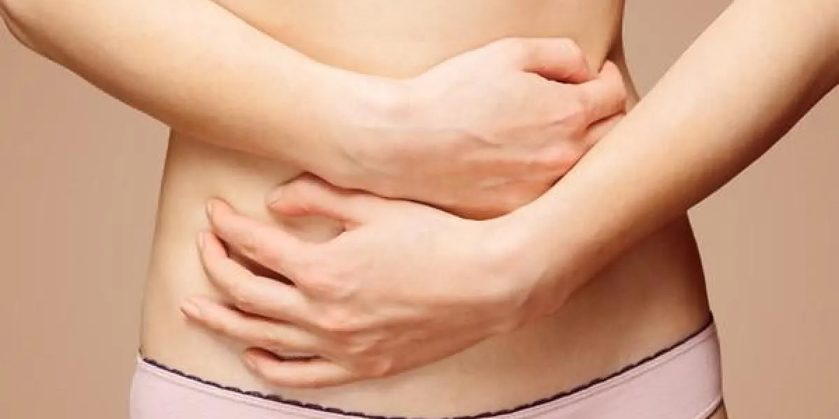 femme méconnaissable tient son abdomen, vue de face, douleur abdominale ou menstruelle
