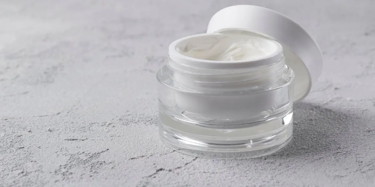 jar of cosmetic cream on gray concrete background blank label for branding mockup