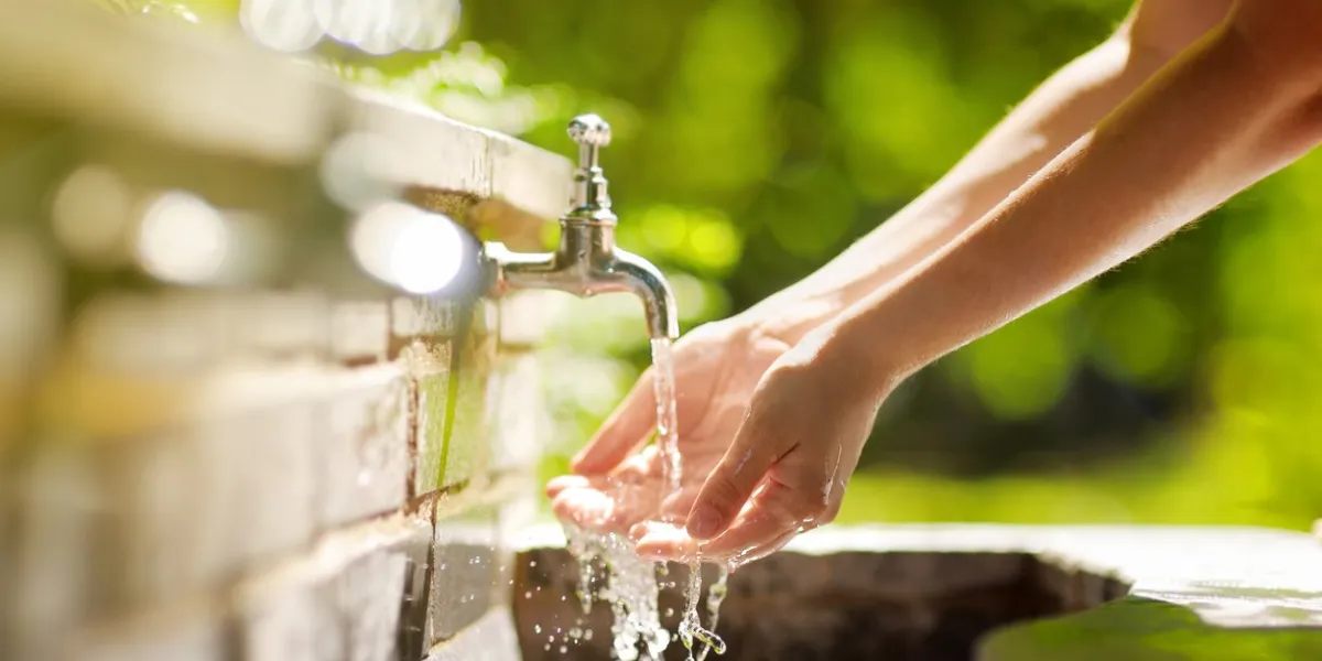 closeup photo of woman washing hands in a city fountain young woman drinking clean water from the fountain in rome, italy