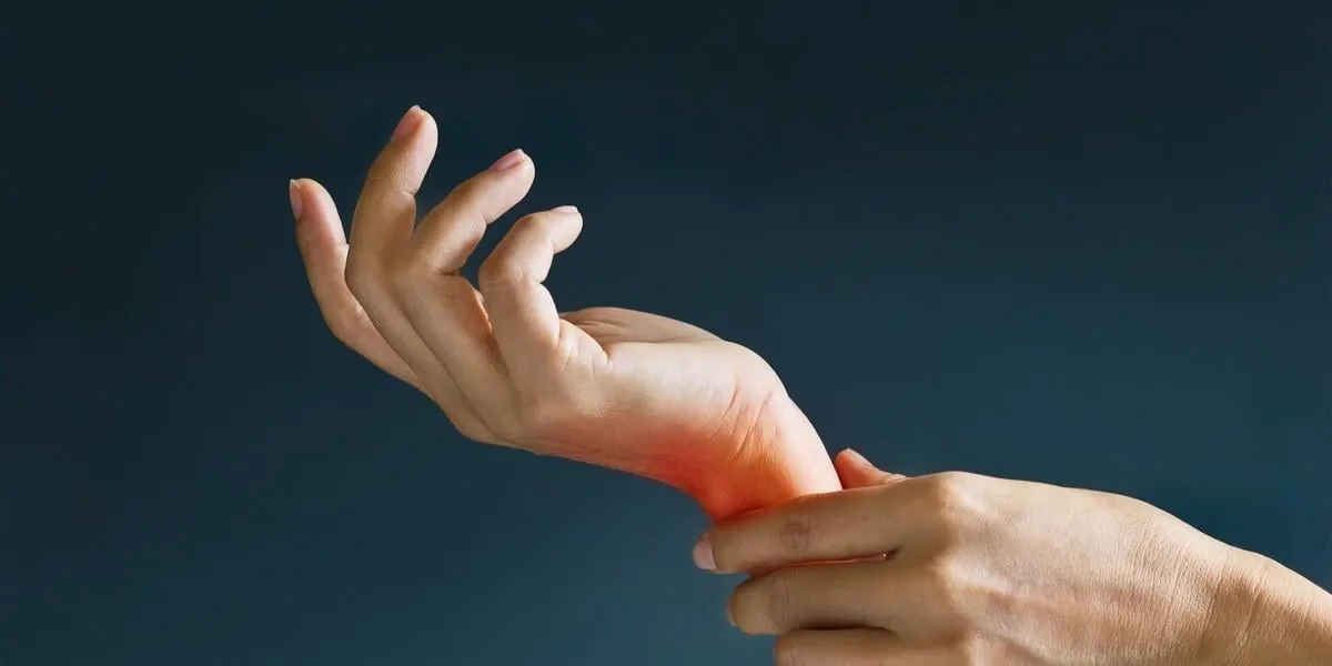 acute pain in a woman wrist, colored in red on dark blue background health issues problems