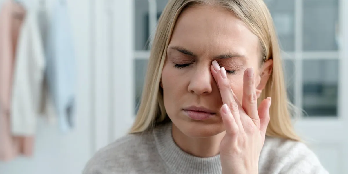 closeup of blonde female feel eye strain or migraine, exhausted young woman worker with headache pain, bad weak blurry vision, eyesight problem