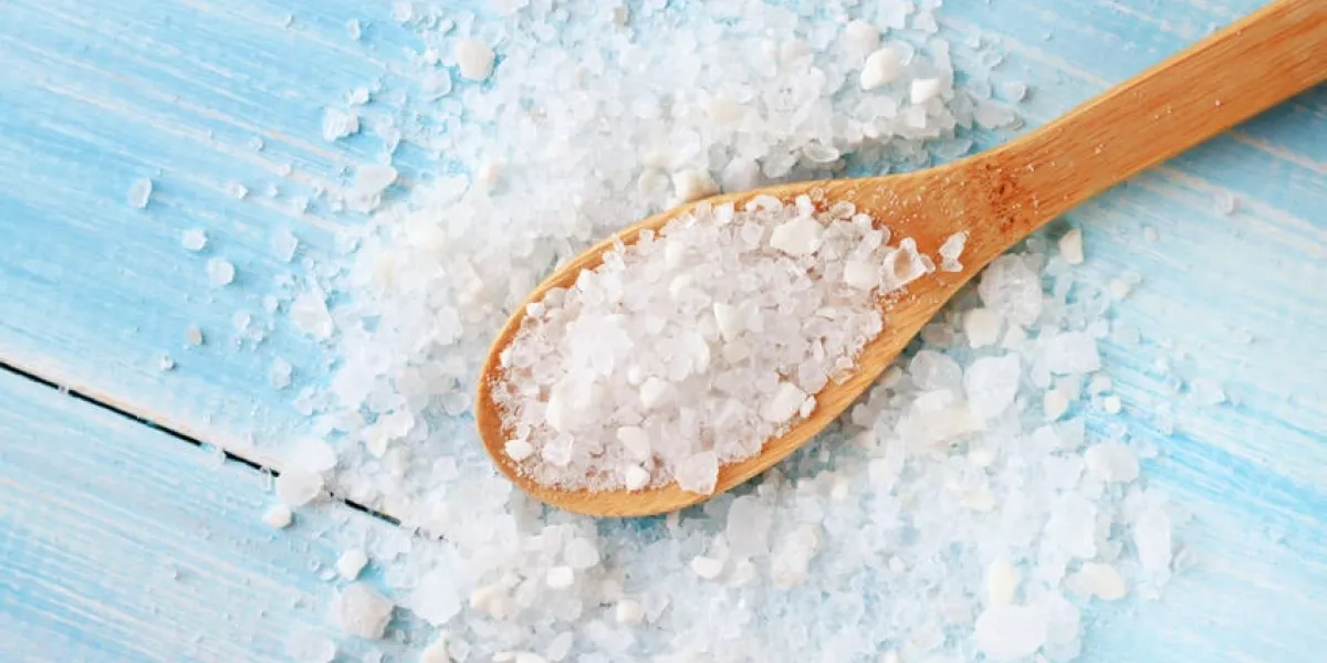 gros grains de sel de mer sur une table bleu clair minable