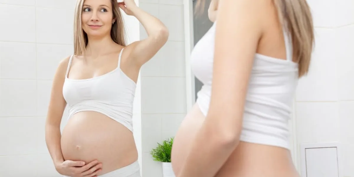 femme enceinte en regardant dans le miroir de salle de bain