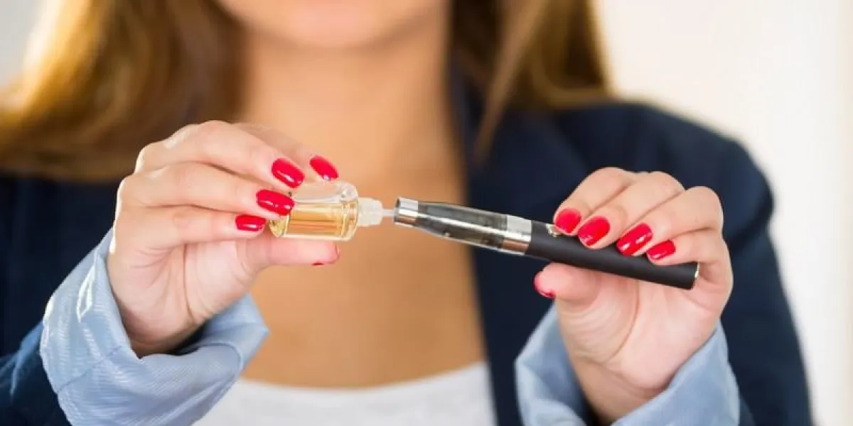 gros plan de la bonne façon de remplir une cigarette électronique, les mains de la femme