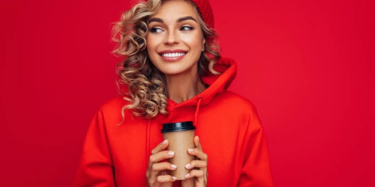 portrait of smiling girl holding disposable mug of coffee