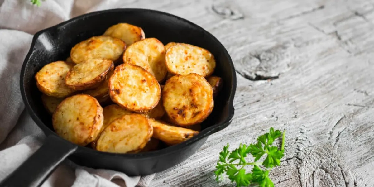 pommes de terre au four dans la poêle sur une surface en bois clair