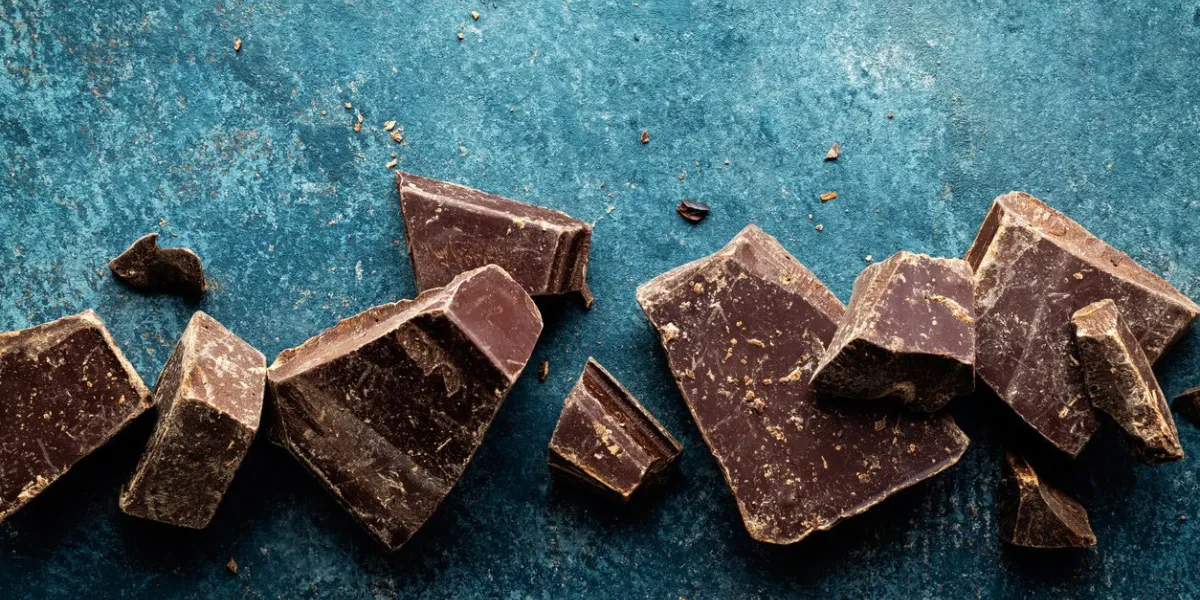 dark chocolate pieces crushed on a dark background, view from above