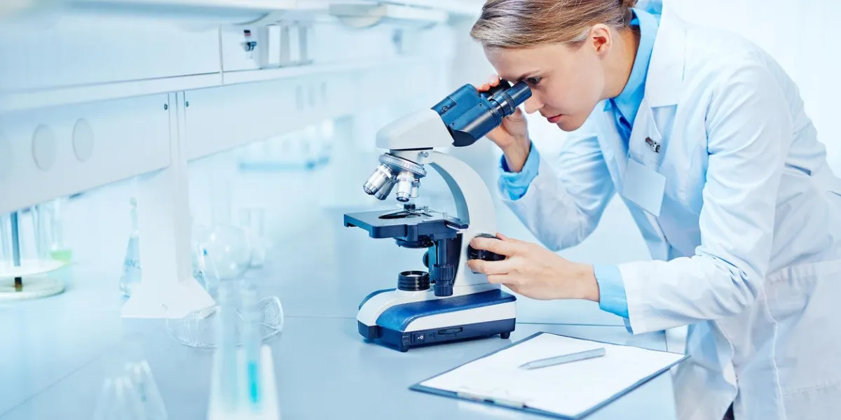 young scientist studying new substance or virus in microscope