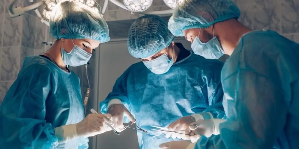 surgeons team working with monitoring of patient in surgical operating room breast augmentation