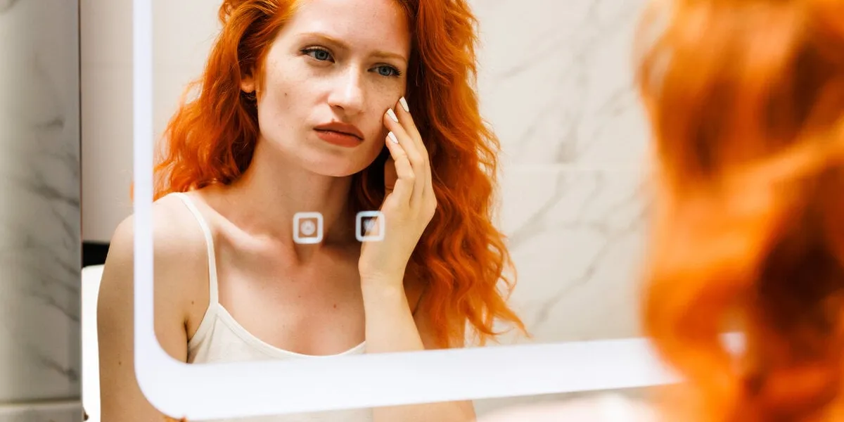 beauty girl looking at mirror while touching her face and checking pimple, wrinkles and bags under the eyes, during morning beauty routine happy smiling beautiful young woman applying moisturizer high quality photo