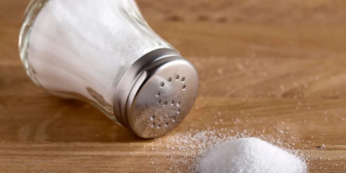 cave à sel en verre traditionnelle et sel renversé sur un fond de bois