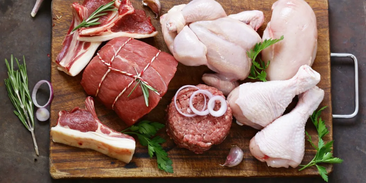 raw meat assortment - beef, lamb, chicken on a wooden board