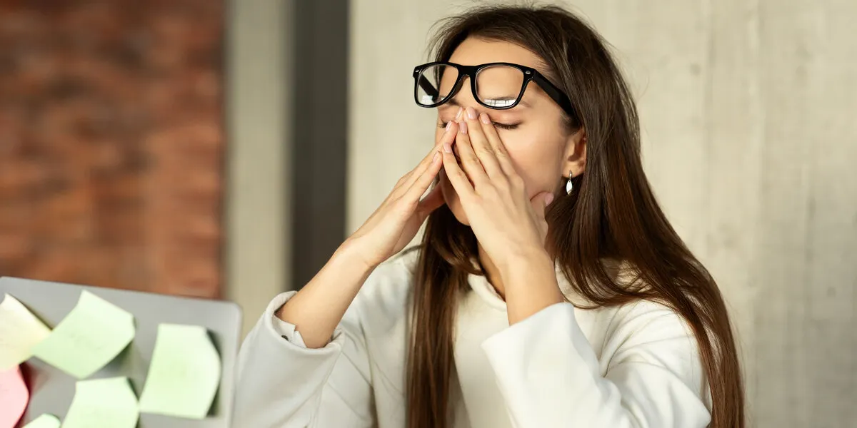 tired freelance girl trying to concentrate, her eyes are dry and hurt