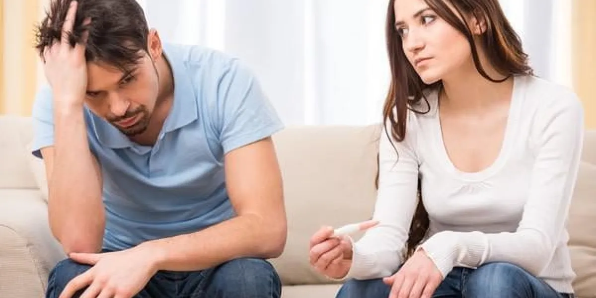 femme contrariée cherche dans le test de grossesse l'homme frustré est assis à côté d'elle