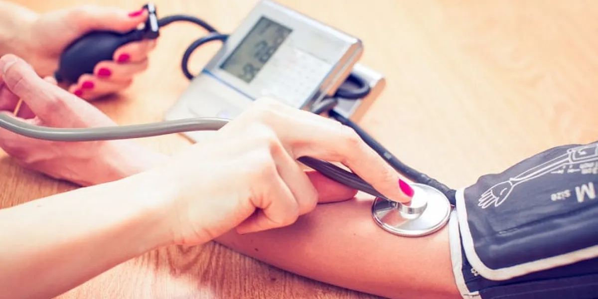 beautiful young female doctor is checking the blood pressure of the patient