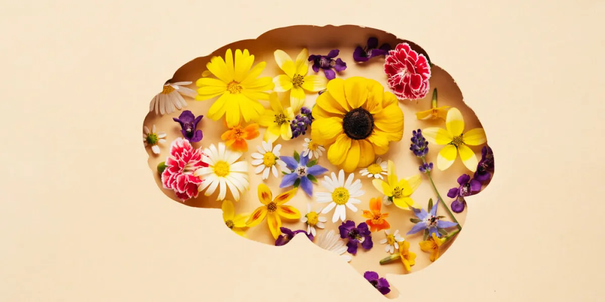 world mental health day concept brain symbol and flowers on a yellow background