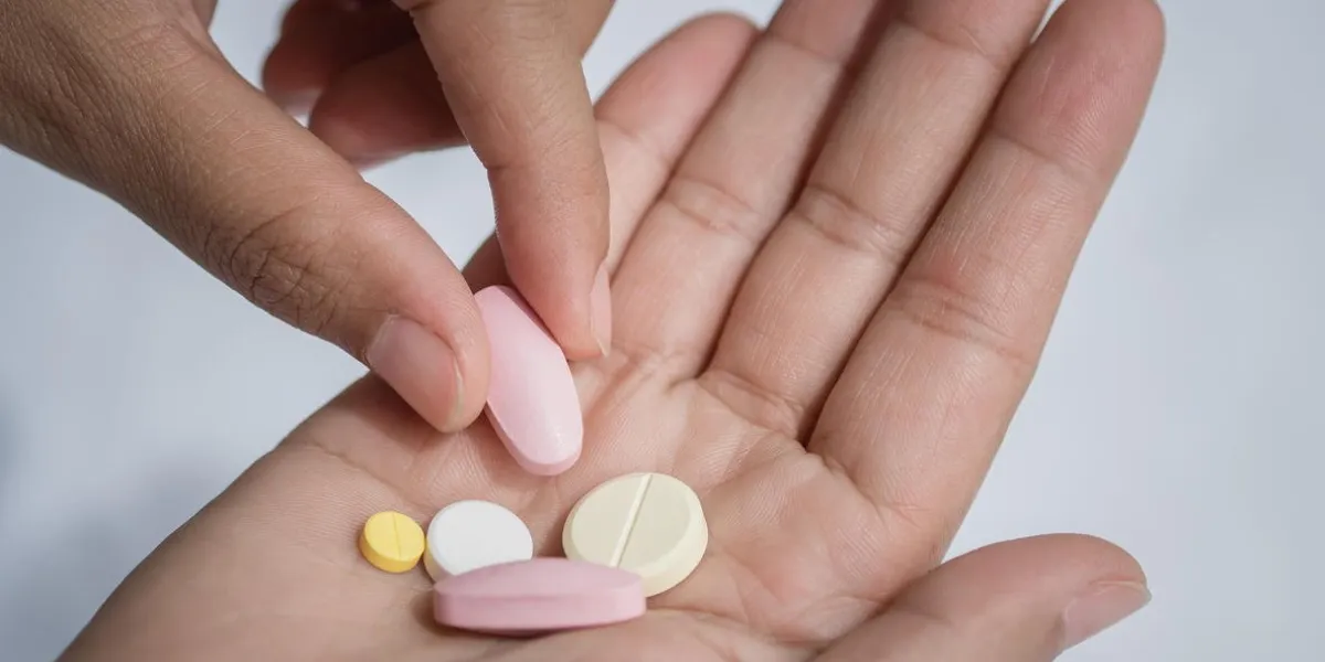 closeup woman hand holding a pill healthcare, medical supplements concept