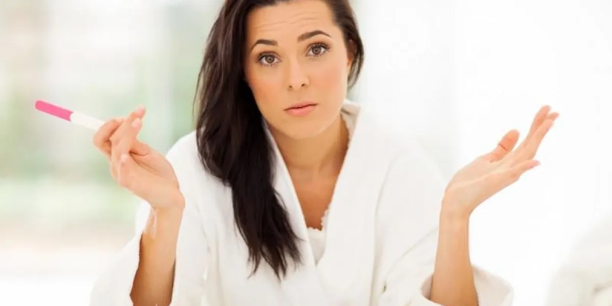 triste jeune femme tenant un test de grossesse se sentant désespérée