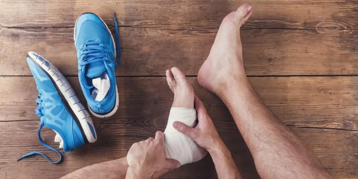 coureur blessé méconnaissable assis sur un fond de plancher en bois