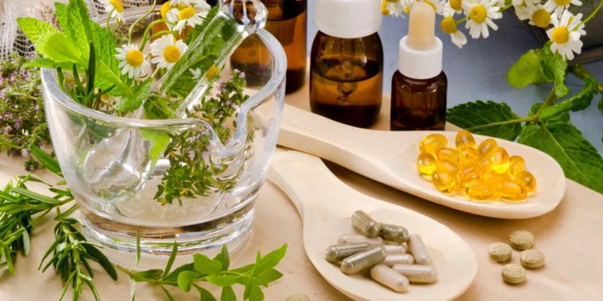 alternative medicine rosemary, mint, chamomile, thyme in a glass mortar essential oils and herbal supplements