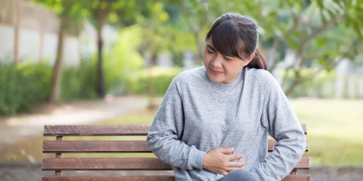 woman has stomachache at park