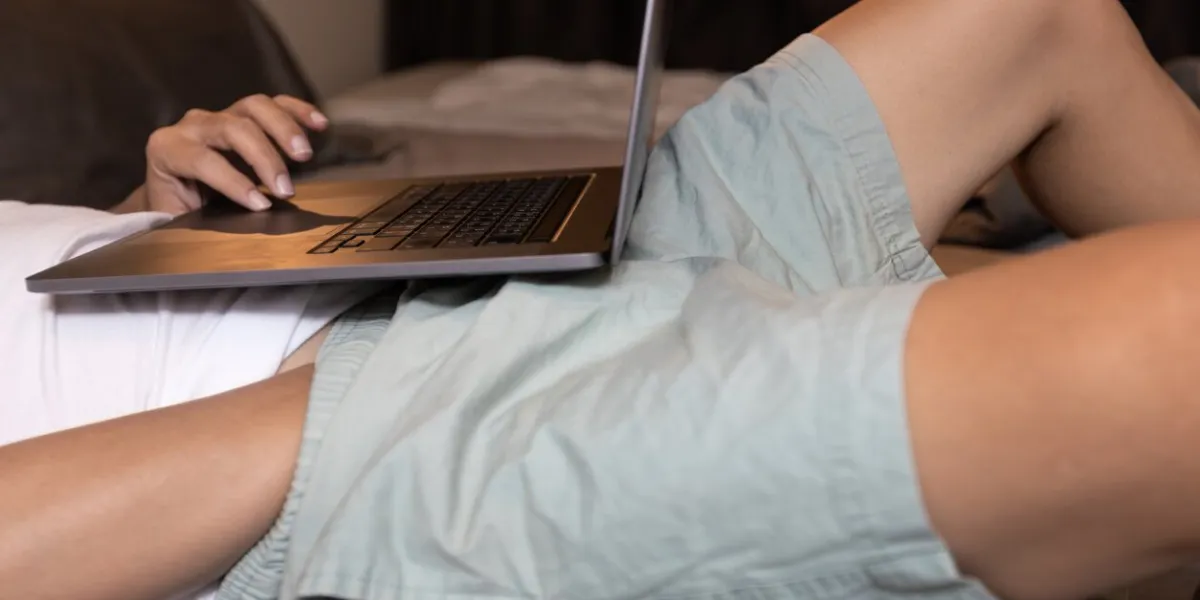 man searching for pornography videos,hand of male in pants,stimulate one's own genitals for sexual pleasure,masturbation while watching porn online or looking pornographic images on laptop computer