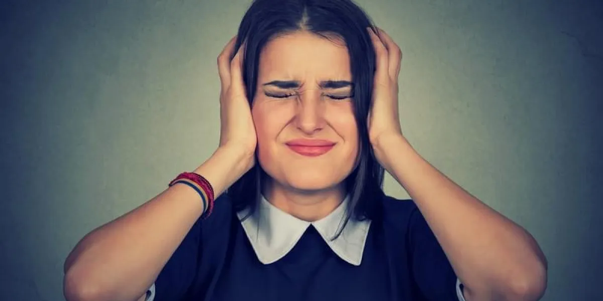 femme frustrée stressée couvrant ses oreilles avec les mains isolées fond gris négative réaction de l'émotion humaine attitude