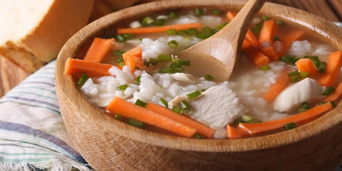soupe de riz au poulet fermer dans un bol en bois horizontal, style rustique