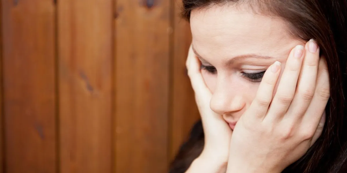 inquiet songeur jeune femme avec sa tête dans ses mains