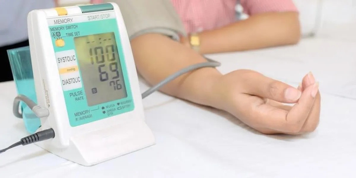 une femme mesurant sa tension artérielle en utilisant un tensiomètre numérique