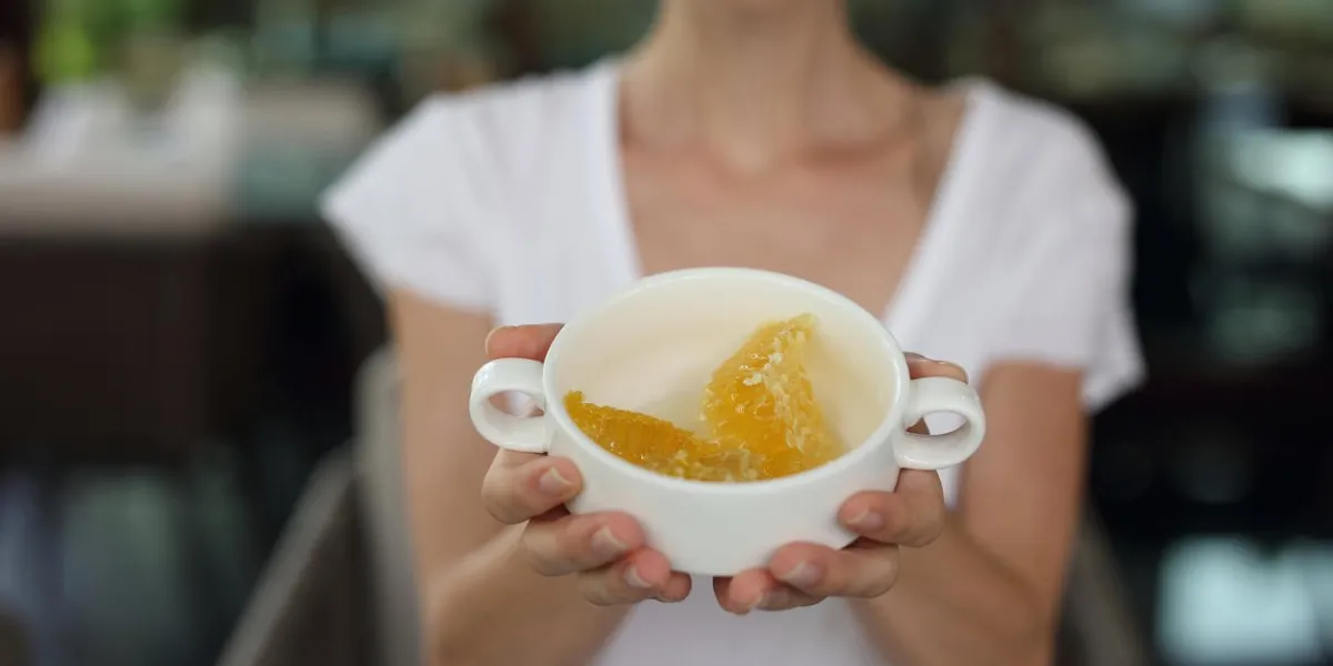 femme tenant le miel, nid d'abeille dans un bol concept d'alimentation et le mode de vie sain
