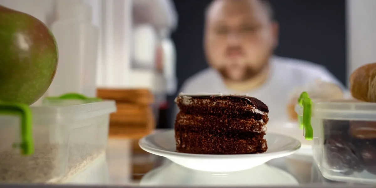 oversize man taking piece of cake from fridge at night, diabetes risk, calories