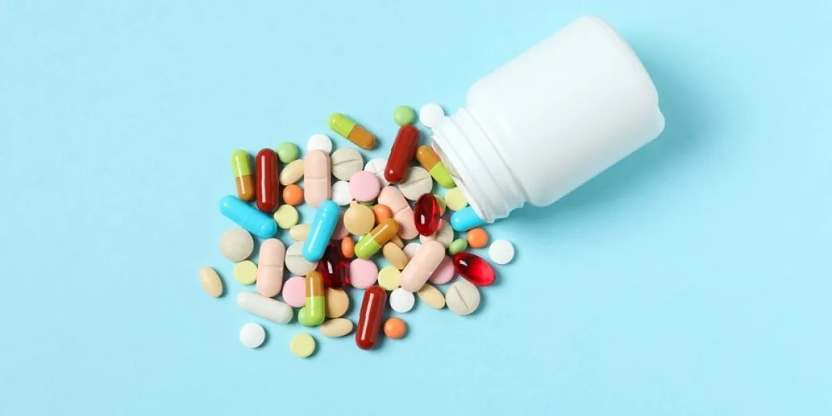 various,pills,pouring,out,of,a,medicine,bottle,on,color