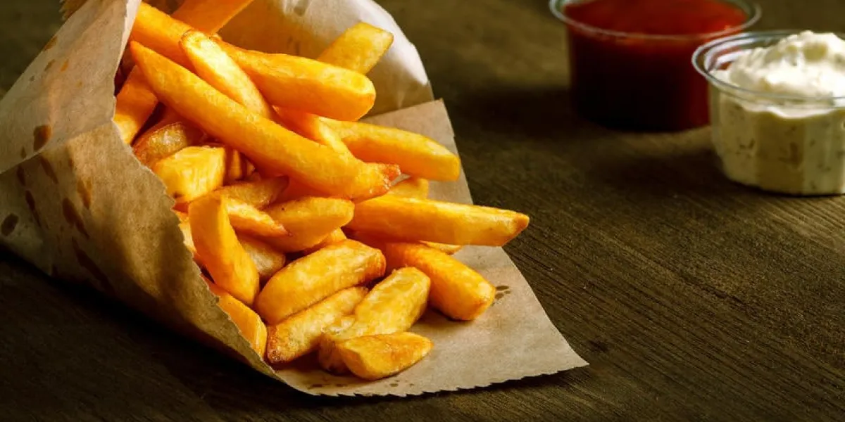 frites fraîches frites avec du ketchup et sauce blanche sur fond en bois