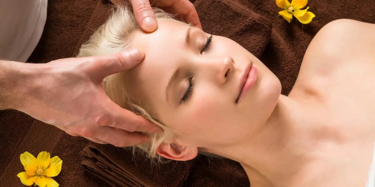 portrait of a young woman receiving head massage at a beauty salon