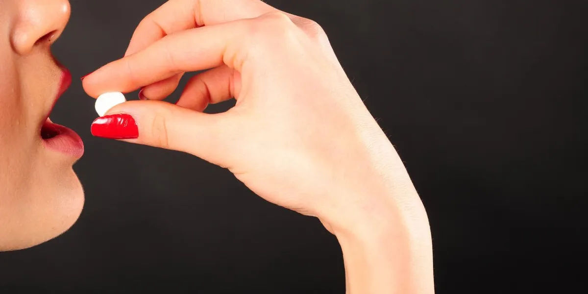 femme prenant une pilule blanche - médecine