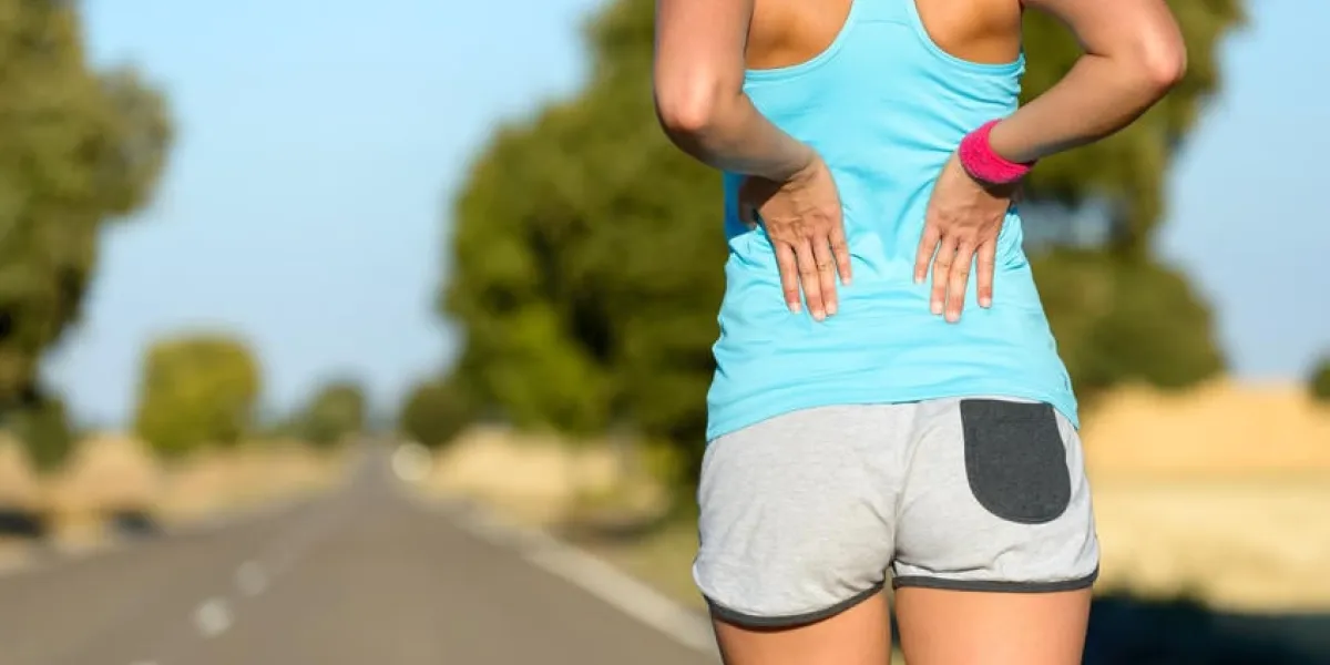 femme coureur athlète lombalgie et douleur femme souffrant de lumbago douloureux lors de la course en route rurale