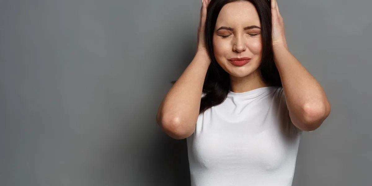 confused woman puts her hands on the head portrait of young sad girl closing her ears, hear nothing, deafness concept