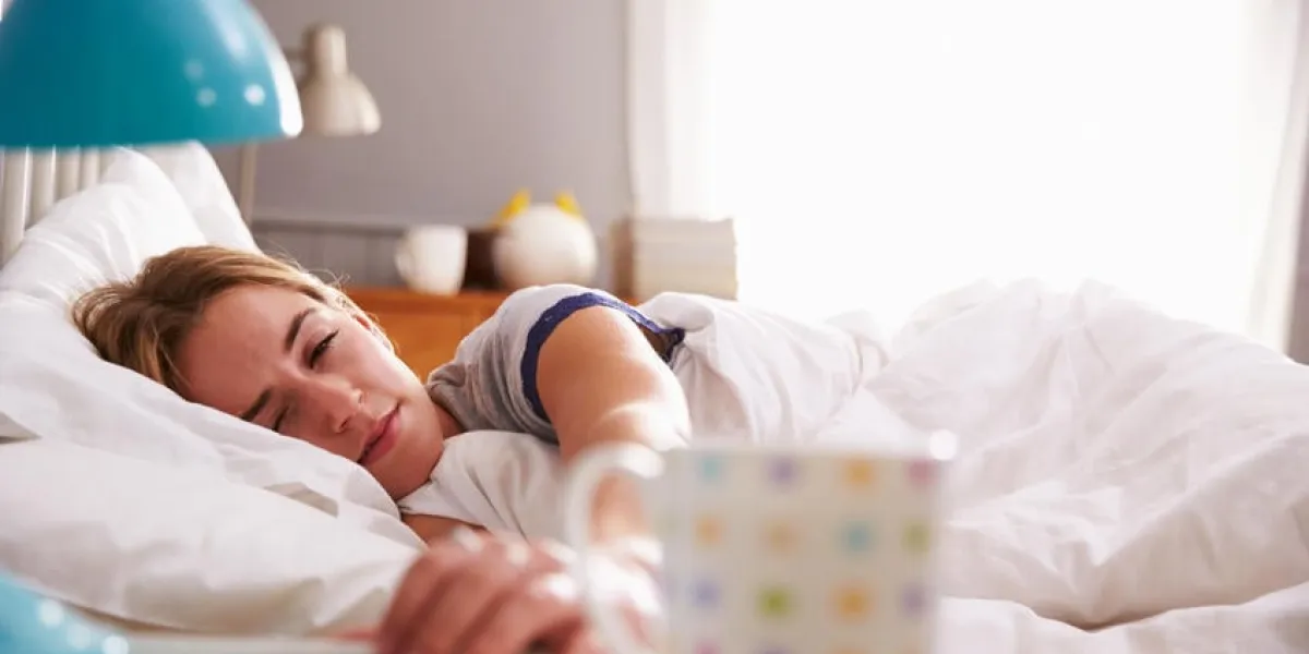 femme endormie étant réveillée par téléphone portable dans la chambre