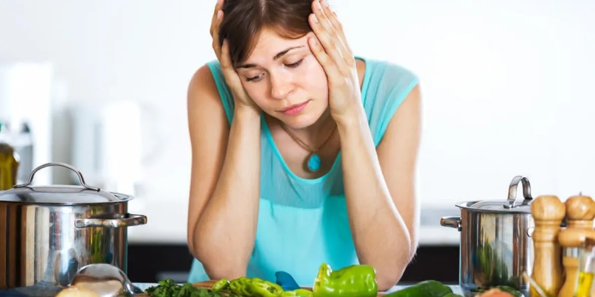jeune femme au visage triste cuisine dîner à la maison intérieure